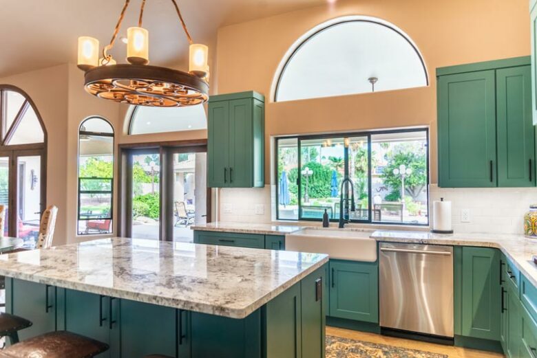 Kitchen remodeling contractor completed home remodeling in Phoenix, AZ kitchen with green cabinets, large feature windows, kitchen island, and sliding doors